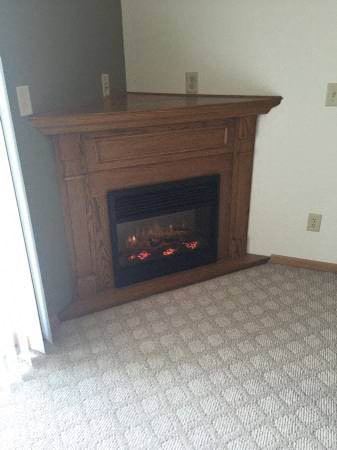a fireplace with a wooden mantle in a living room